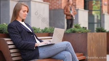 坐在办公室外的商务妇女在膝上型电脑上工作